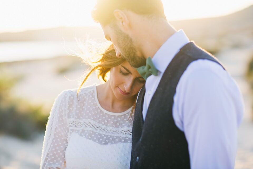 Romantisches Hochzeitsfoto bei Sonnenuntergang in Tirol, glückliches Brautpaar im Liebesmoment.