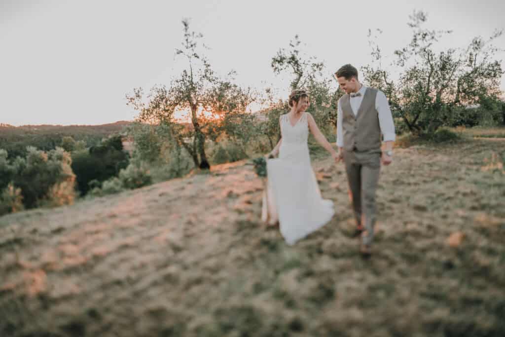Hochzeitsfotograf Tirol, Brautpaar im Sonnenuntergang auf dem Feld, emotionale Hochzeitsfotos, natürliche Landschaftsaufnahmen, internationale Hochzeitsfotografie.