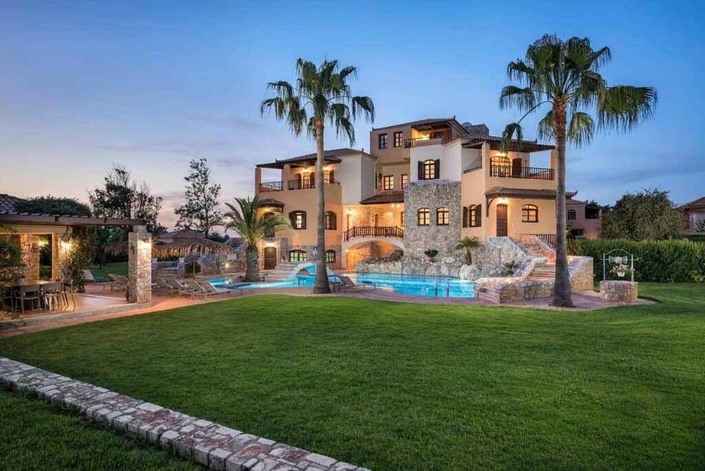 Luxuriöses Villa mit Pool und Palmen bei Sonnenuntergang in Tirol, Österreich.