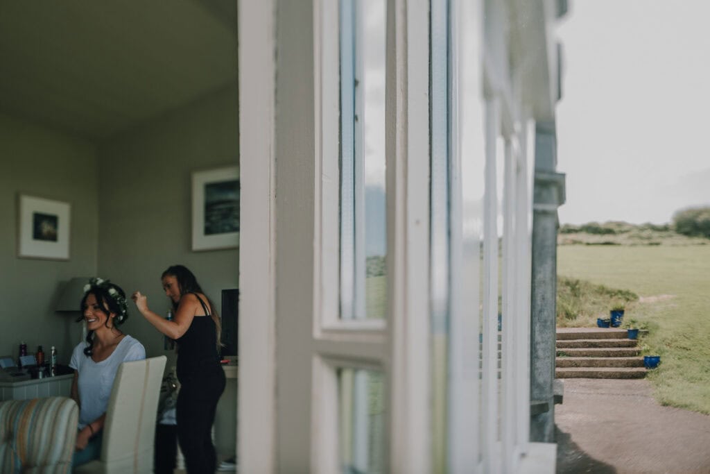 Braut bekommt Frisur mit Blumenkranz vor der Hochzeit in Irland. 