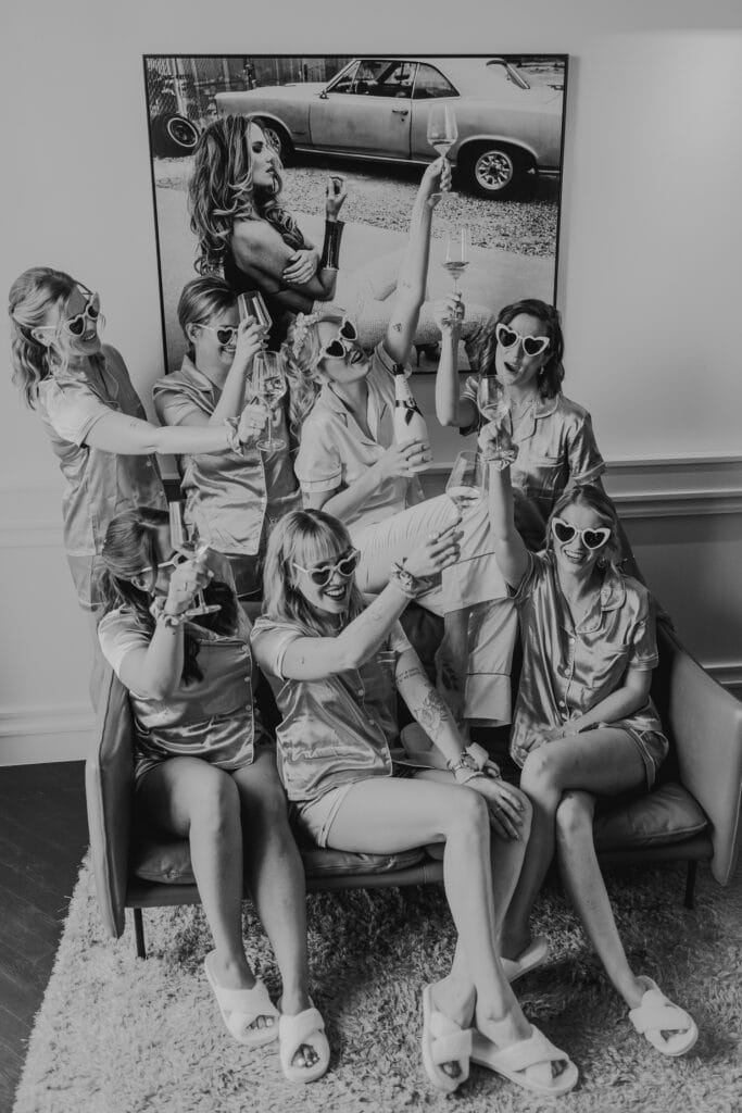 Brautjungfern feiern mit Champagner in passenden Pyjamas und Herzbrillen. Hochzeitsfotograf München.