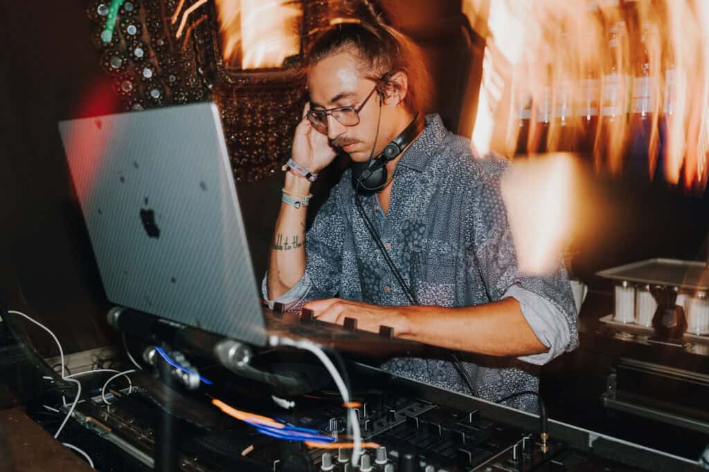 DJ mit Laptop und Kopfhörern bei einer Hochzeitsfeier in München.