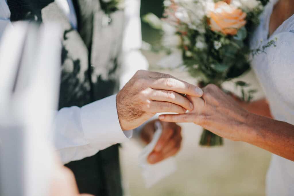 Bräutigam steckt der Braut den Ehering an. Hochzeitsfotograf Irland.