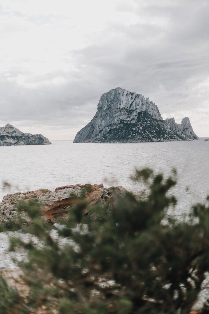 Felsinsel Es Vedrà, Ibiza, im Meer unter bewölktem Himmel. Küstenlandschaft.