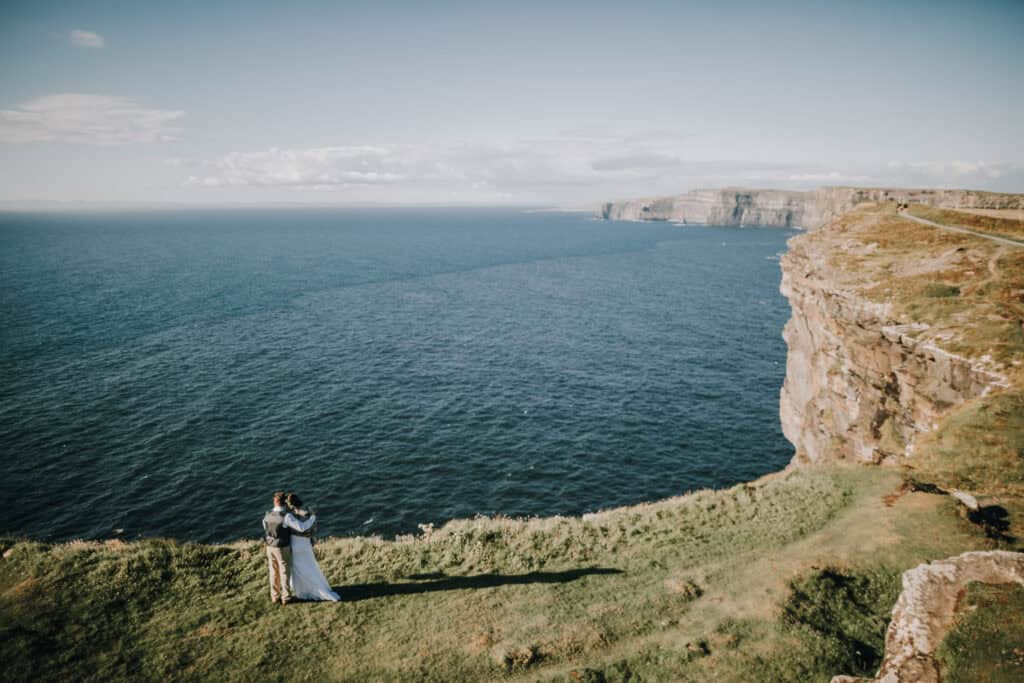 Brautpaar umarmt sich auf den Klippen von Moher, Irland. Atlantik im Hintergrund.