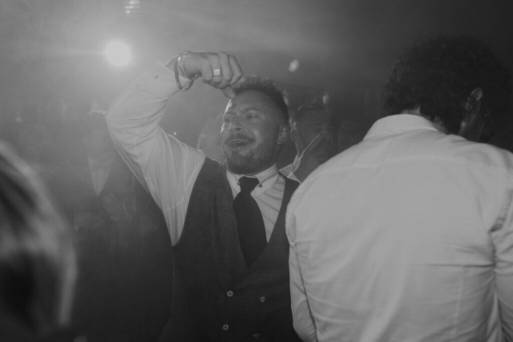 Gast tanzt ausgelassen auf einer Hochzeit. Feier in München.